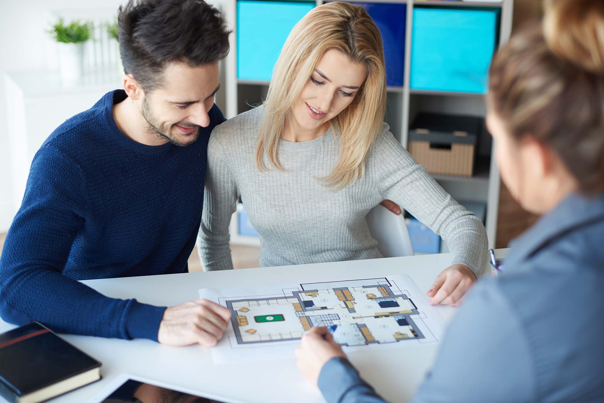 Couple meeting with real estate agent looking at premium floorplans